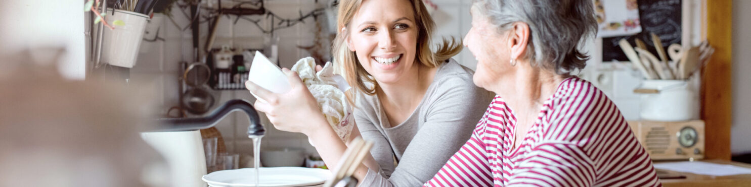 An,Elderly,Grandmother,With,An,Adult,Granddaughter,At,Home,,Washing